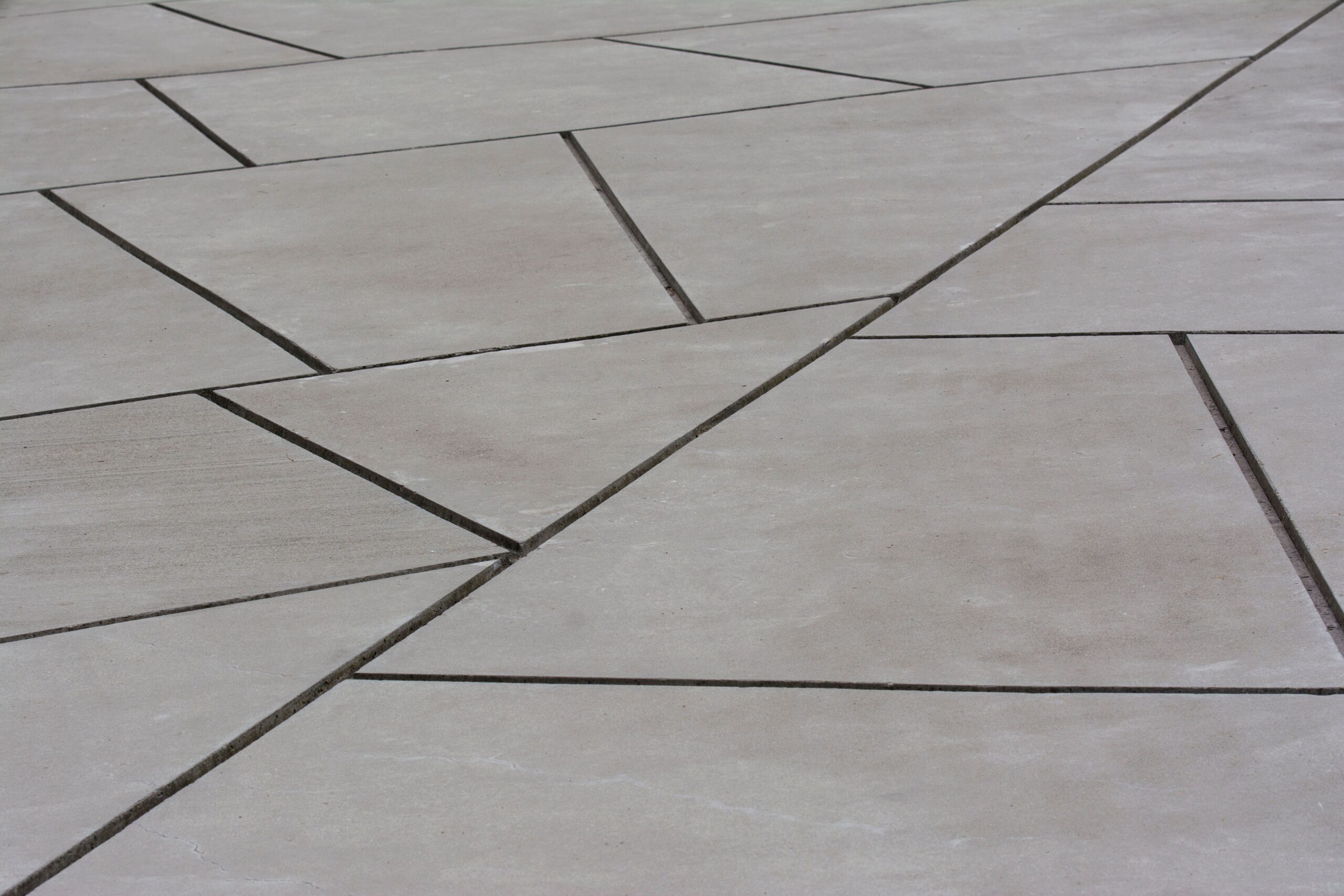Abstract geometric concrete surface showing intersecting lines and shapes, ideal for backgrounds.